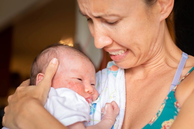 A Worried Mother Holding Her Sick Newborn Baby At Home. Infant S